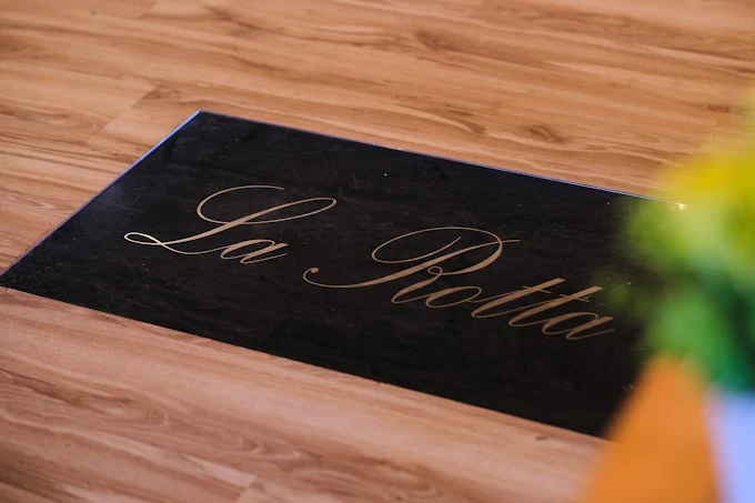 La Rotta - gravirana tabla sa logom na ulazu u restoran