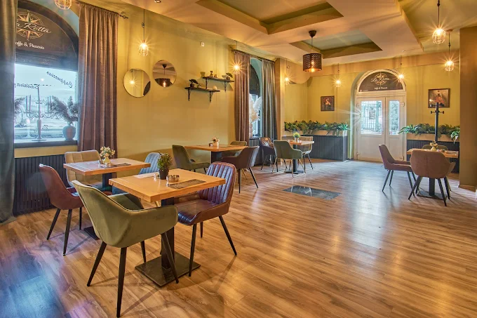 Sala za sedenje u La Rotta restoranu, Železnik, sa stolovima pored prozora